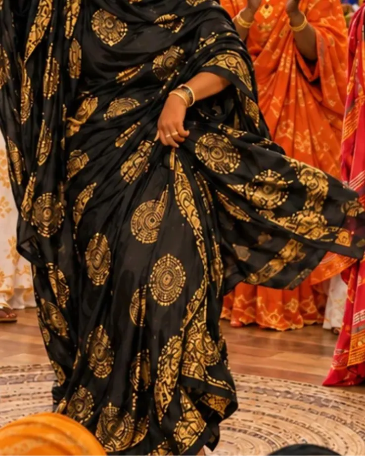A woman in a black and gold dirac dances at a Buraanbur Night celebration.