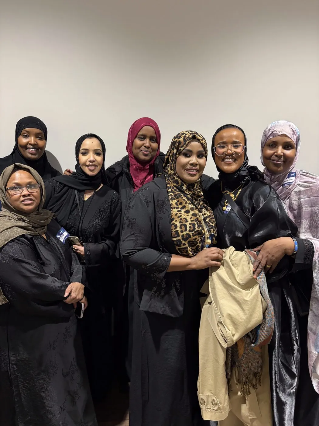 A group of women from the community smile together.