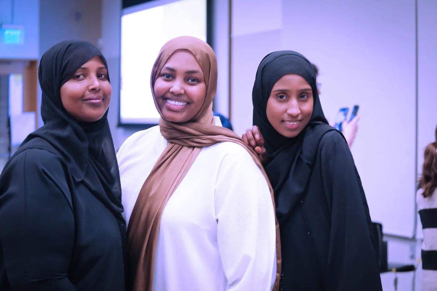 Three women from the community pose together.