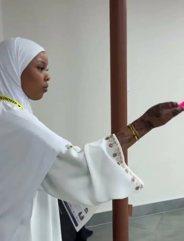 A volunteer in a white hijab blows bubbles for the children.