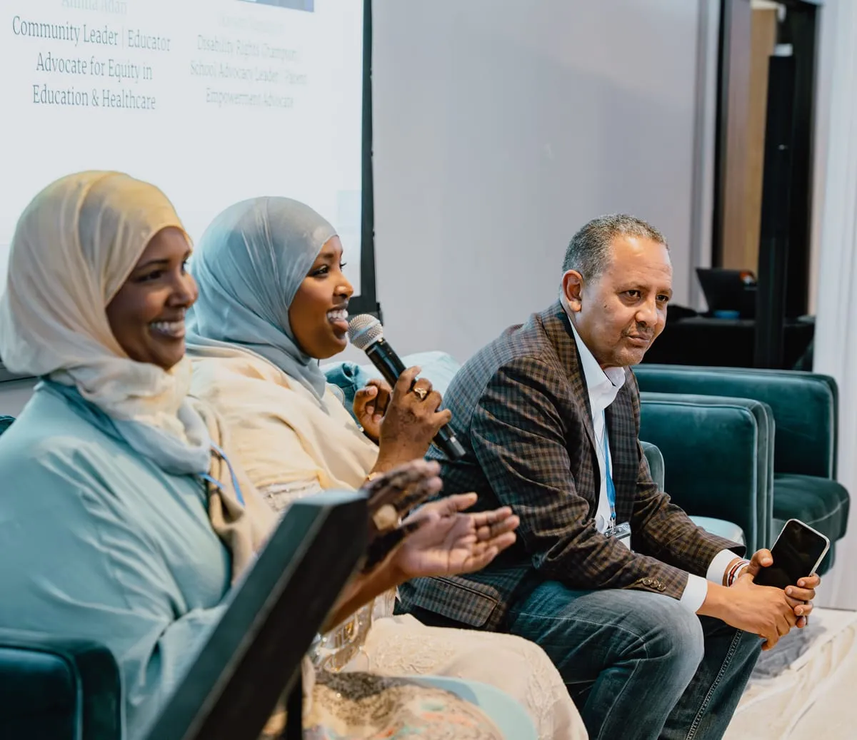 Three panelists share a laugh during a summit discussion.