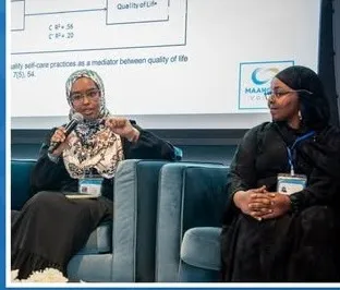 Two panelists speak with a presentation slide behind them.