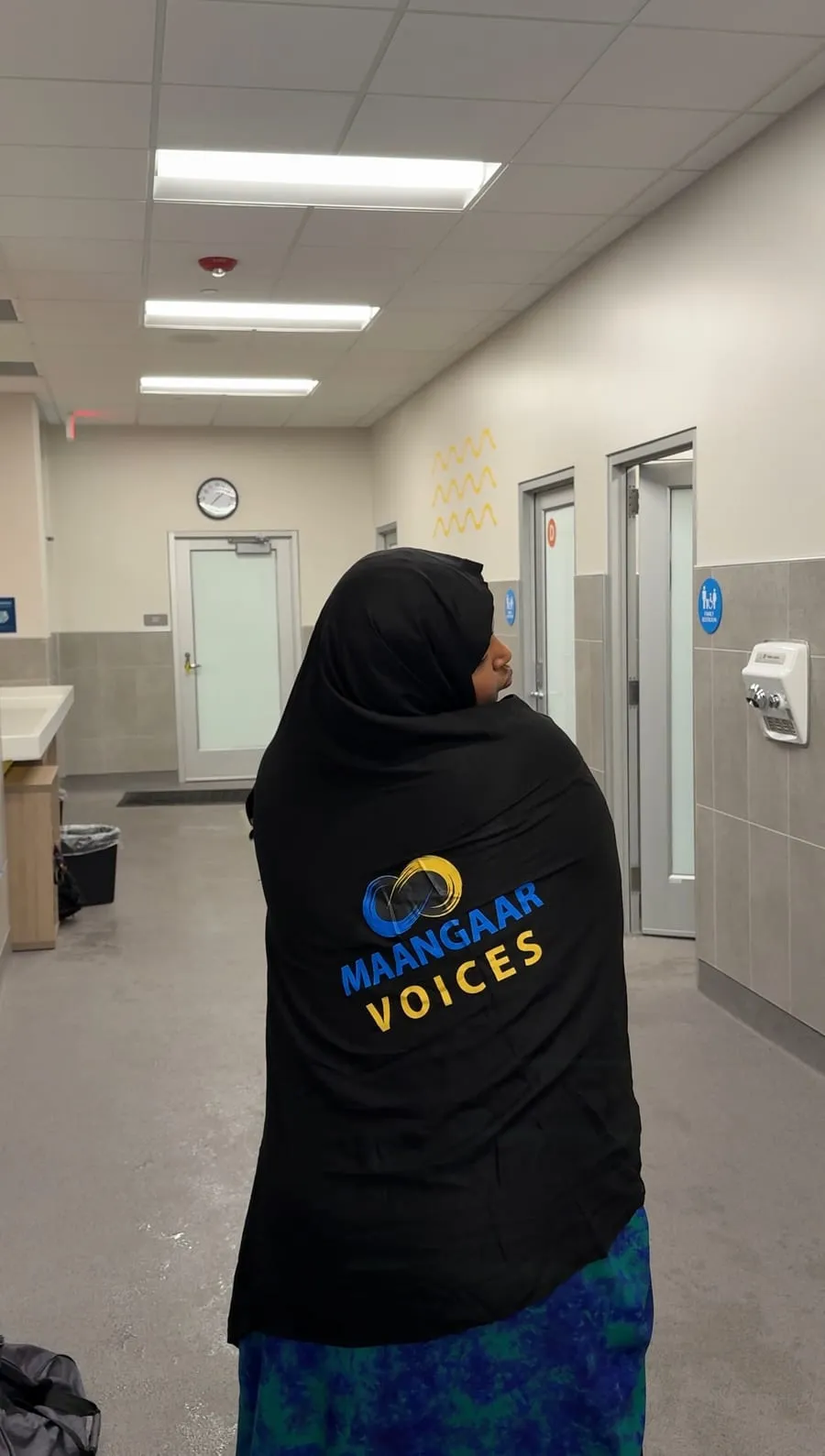 A participant in a Maangaar Voices hoodie walks toward the pool.